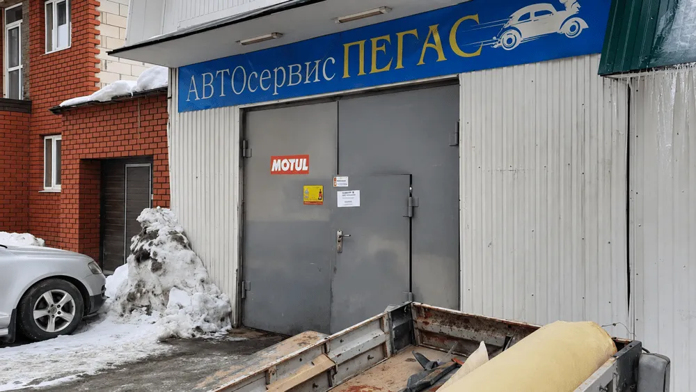 Вход в автосервис «Пегас» на Пигасовской, 11 в Перми: ворота бокса и синяя вывеска